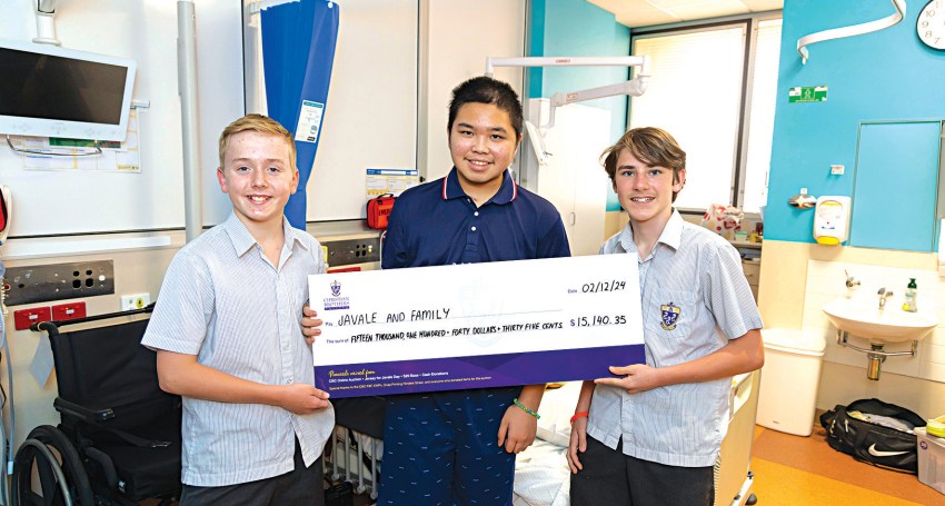 Emmet Fay (left) and Sebastian Spiby present a mock cheque to Javale at the Women’s and Children’s Hospital.